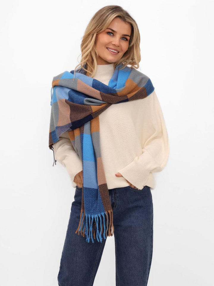 Woman wearing a plaid scarf with blue, brown, and gray colors on a white background