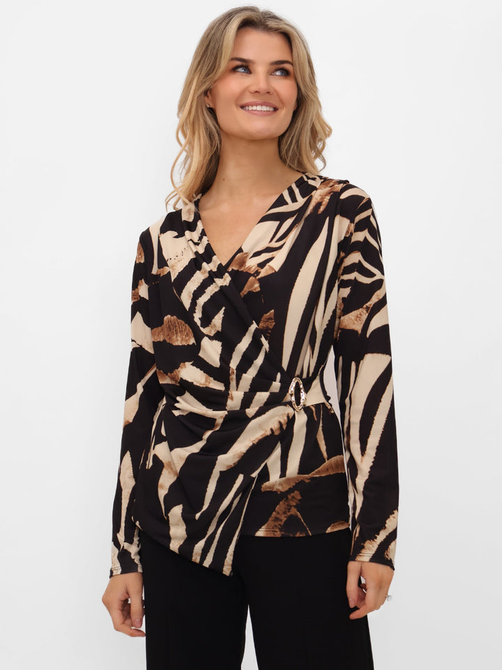 Woman wearing a patterned blouse with a neutral background