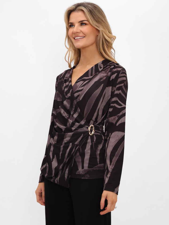 Woman wearing a patterned top with a belt on a white background