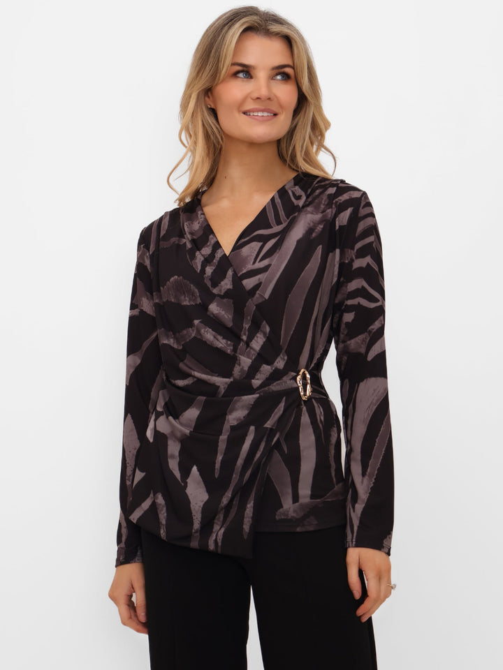 Woman wearing a patterned blouse with a belt on a white background