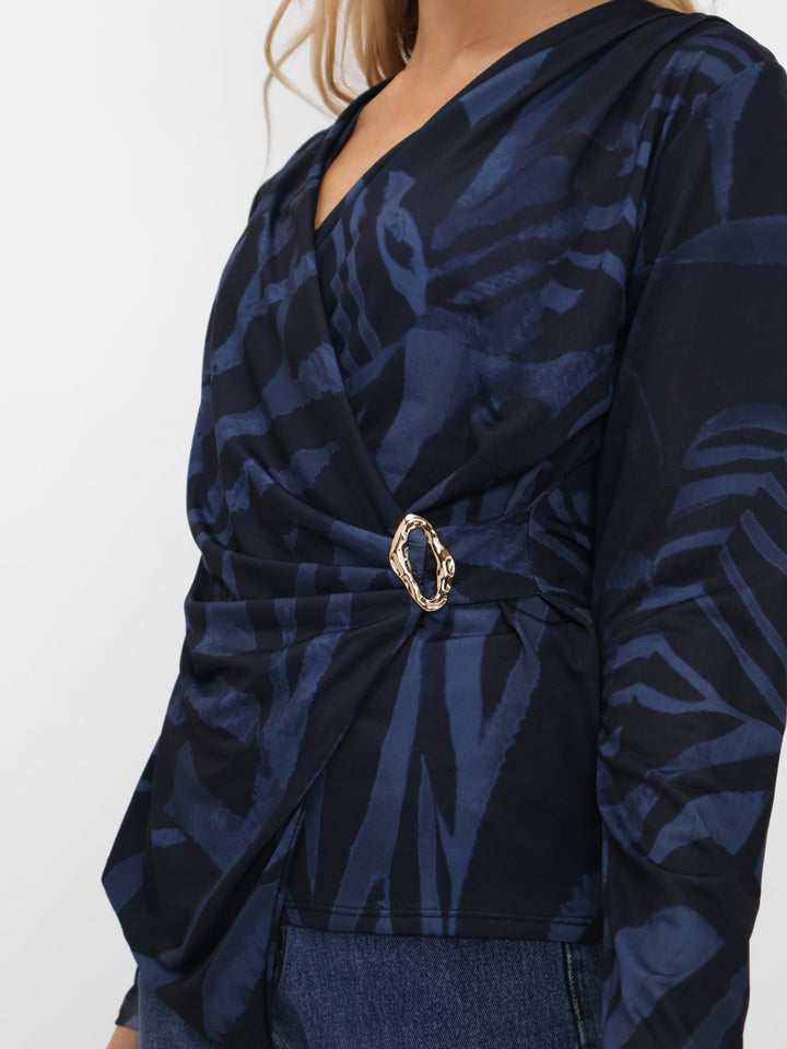 Navy patterned top with a gold belt on a white background