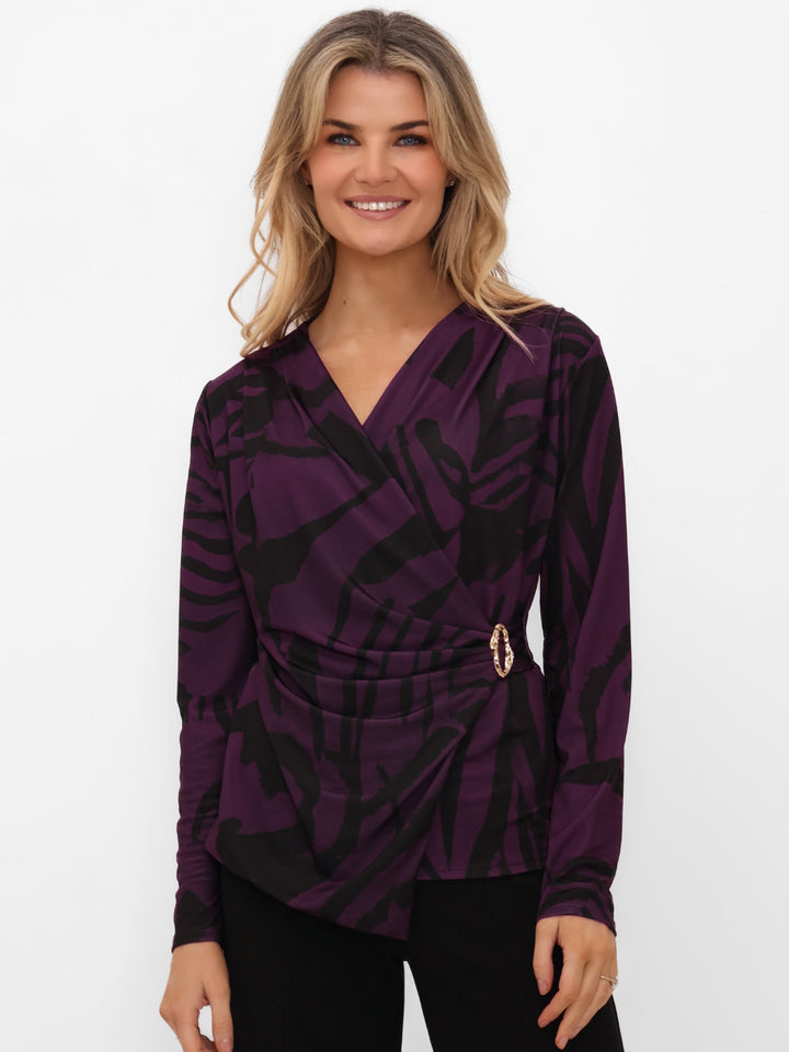 Woman wearing a purple patterned blouse on a white background