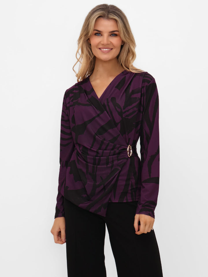 Woman wearing a purple patterned top on a white background