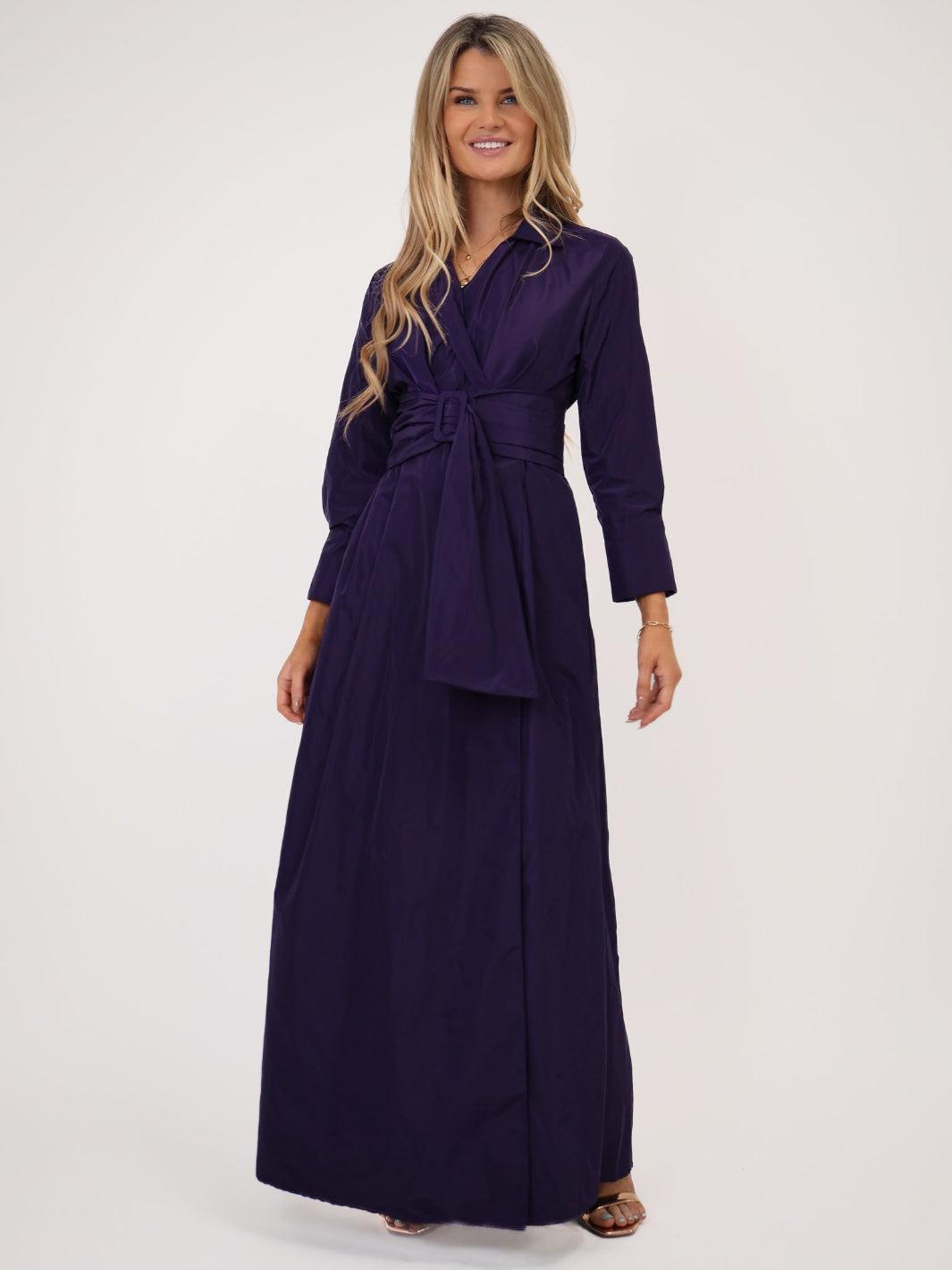 Woman wearing a long purple dress on a white background