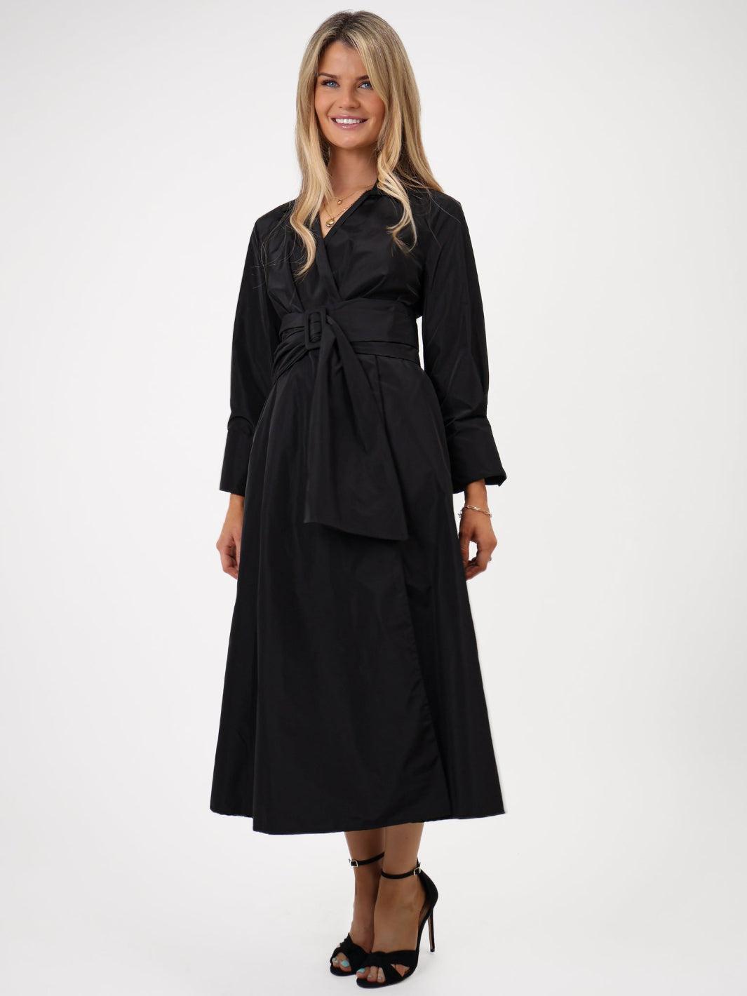 Woman wearing a black dress with a belt on a white background
