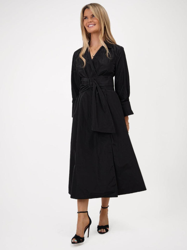Woman wearing a black dress with a belt on a white background