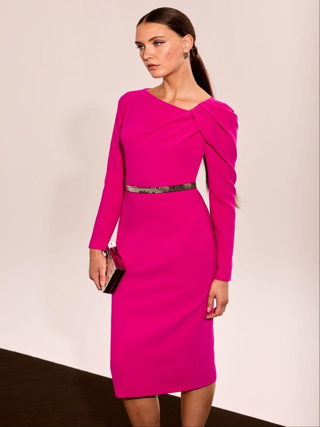 Woman wearing a bright pink dress with a plain background