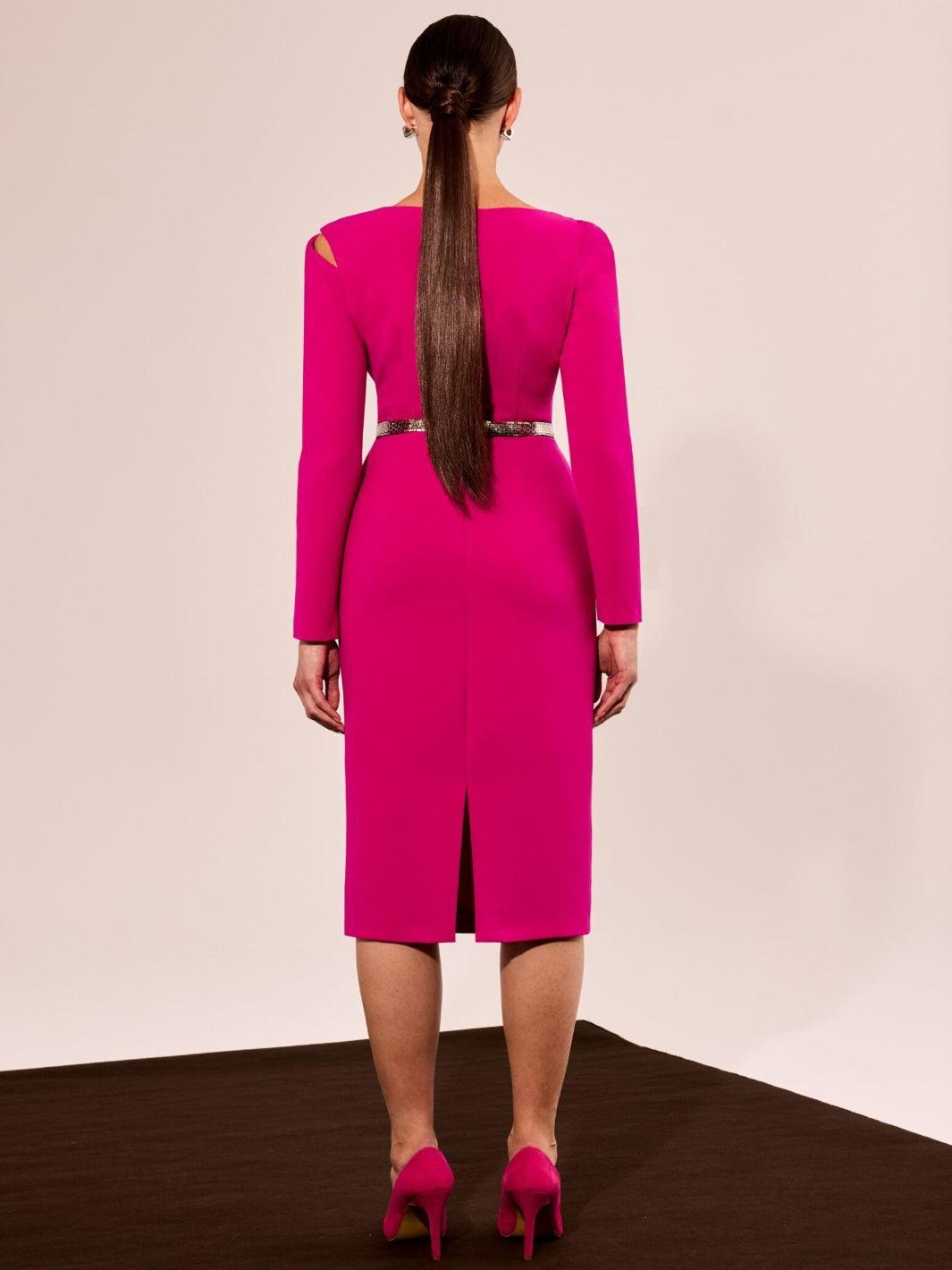Woman wearing a bright pink dress with a cutout back on a plain background
