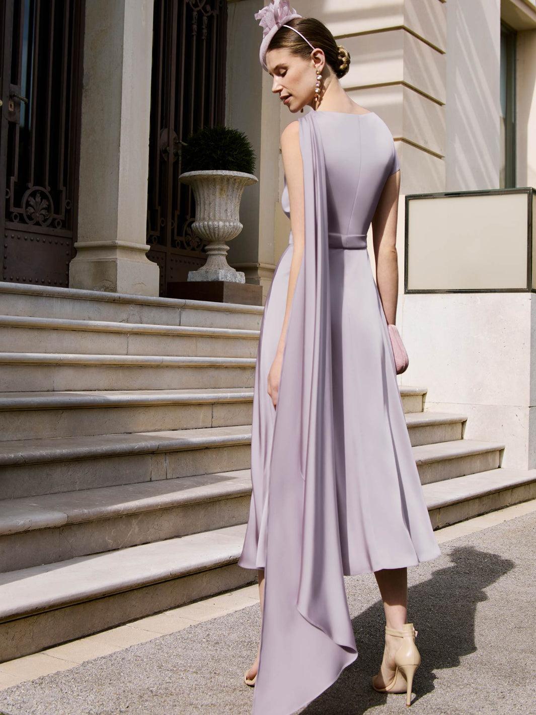 Woman in a lavender dress standing on steps outside a building