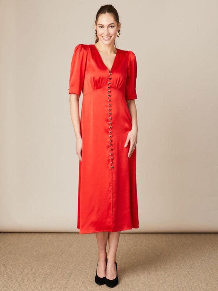 Woman wearing a red dress with a beige background