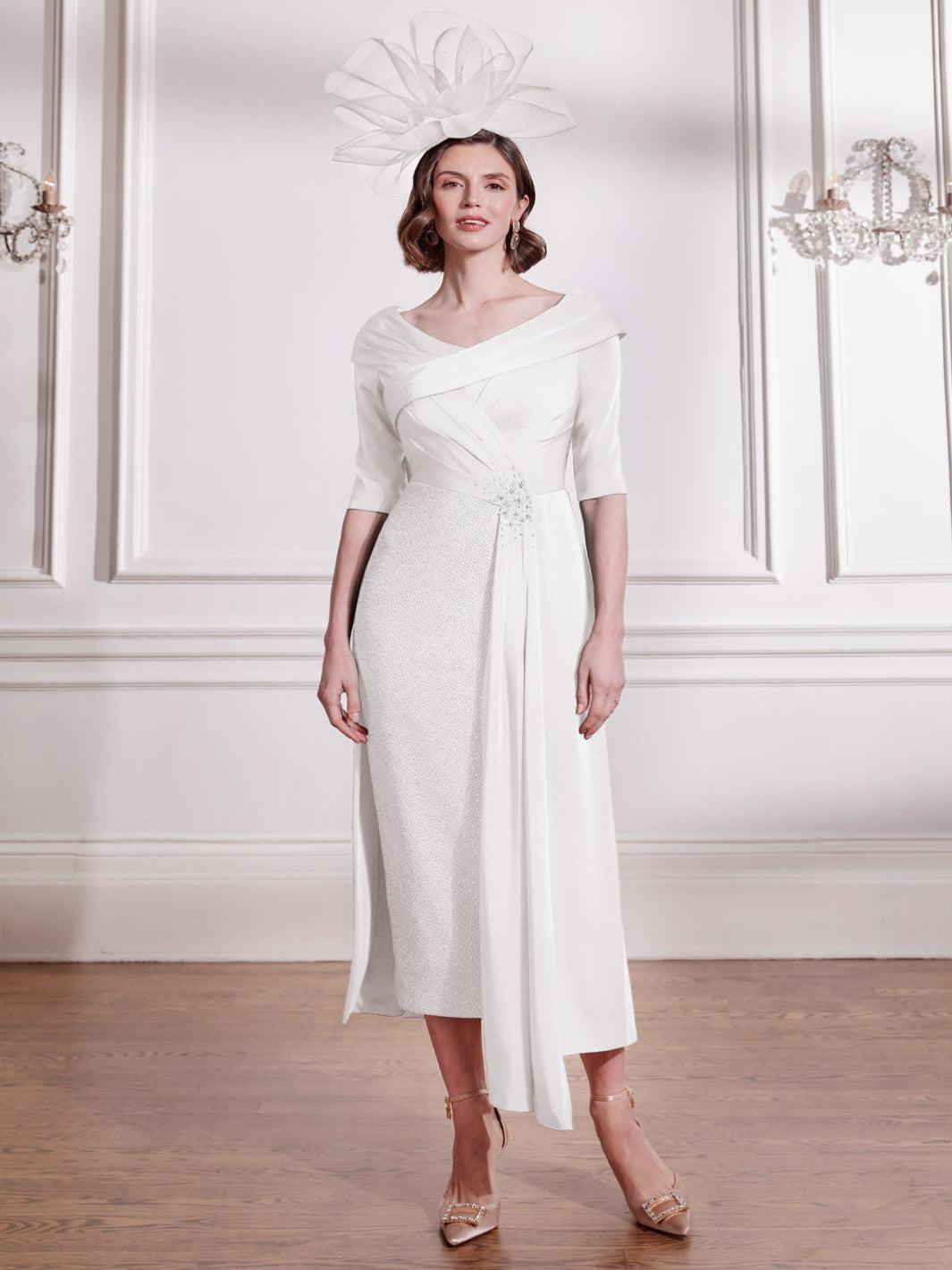 Woman wearing a white dress with a floral headpiece in an elegant room.