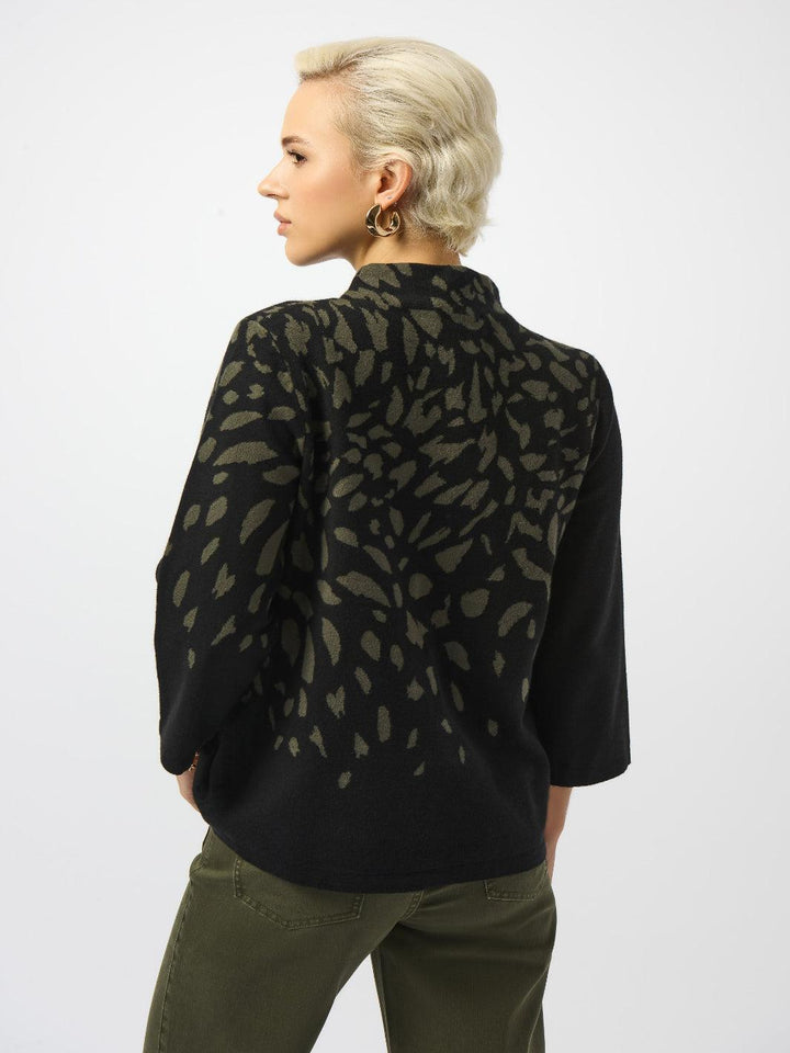 Person wearing a black patterned shirt and green pants on a white background