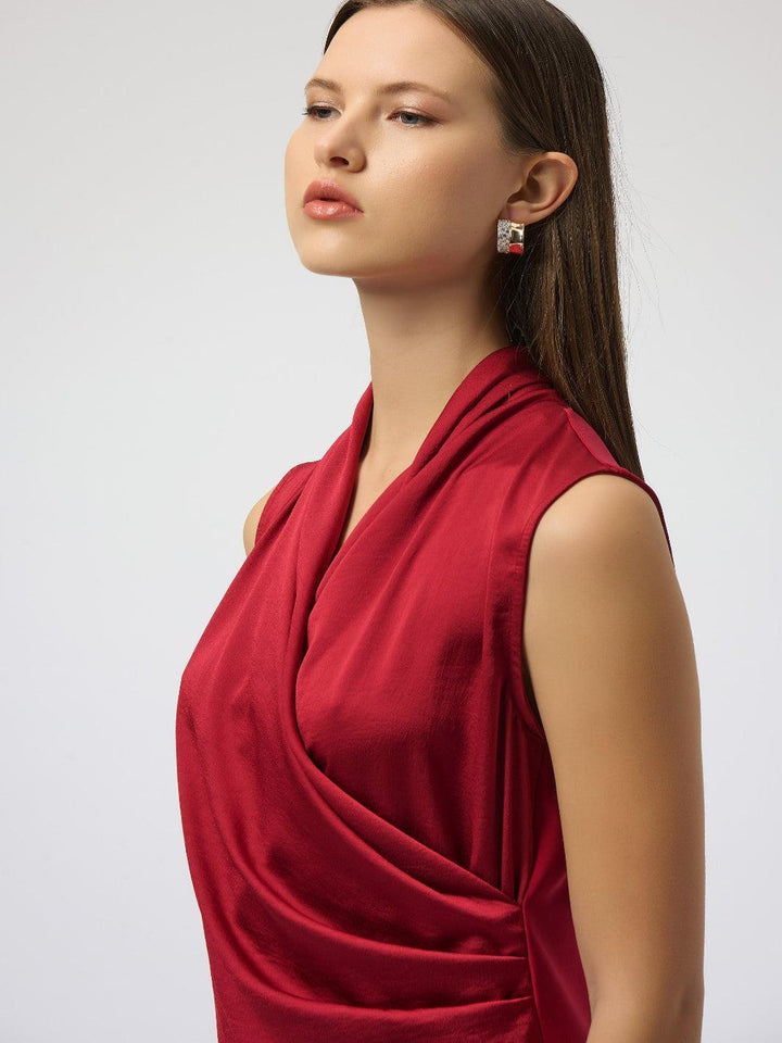 Woman wearing a red sleeveless top against a white background