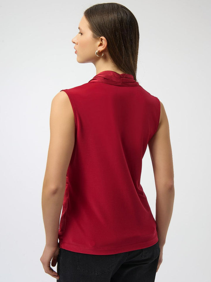Woman wearing a red sleeveless top on a white background