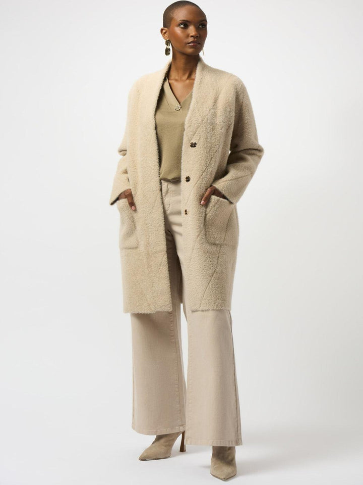 Woman wearing a beige coat and matching outfit on a white background