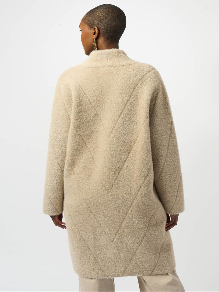 Person wearing a beige quilted coat on a white background