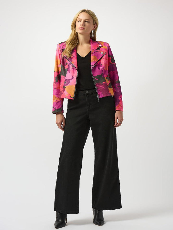 Woman wearing a colorful floral jacket with black pants on a white background