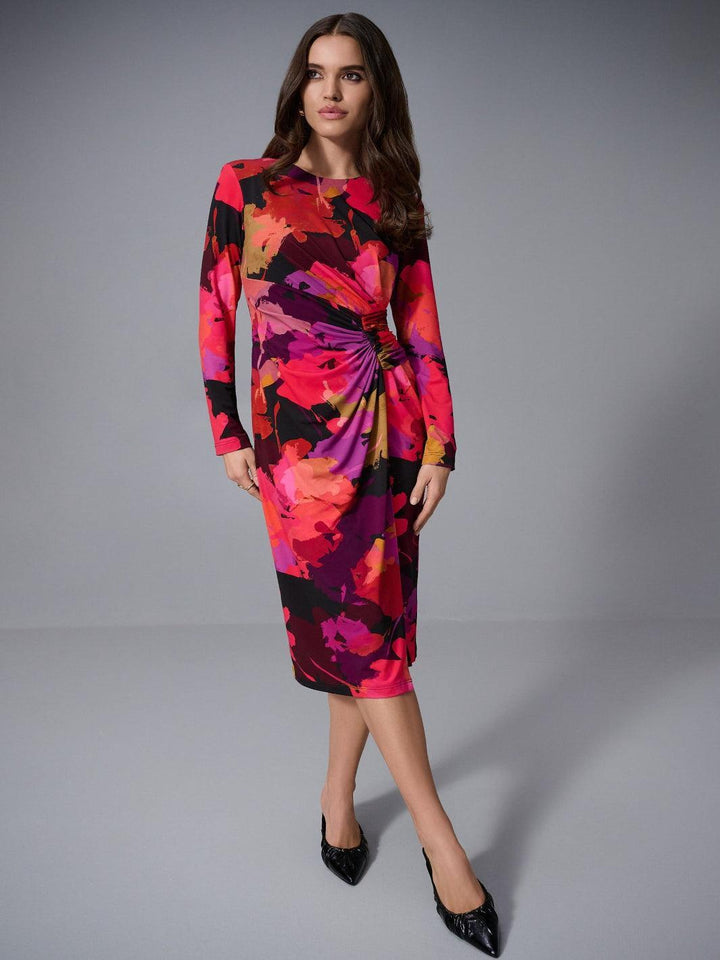 Woman wearing a colorful floral dress on a gray background
