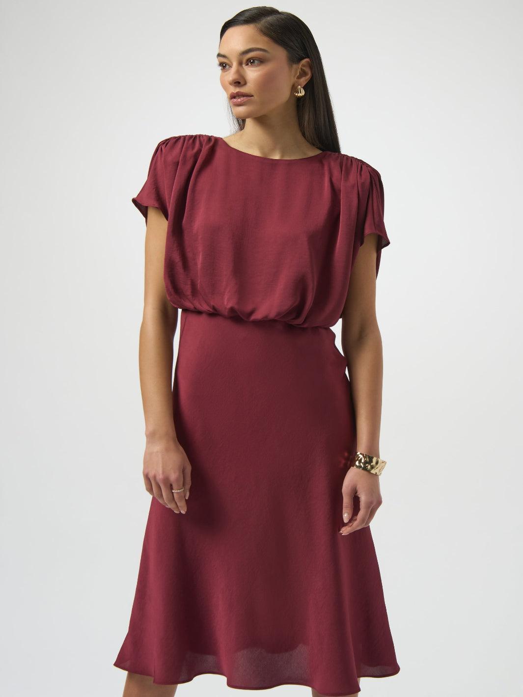 Woman wearing a burgundy dress against a white background