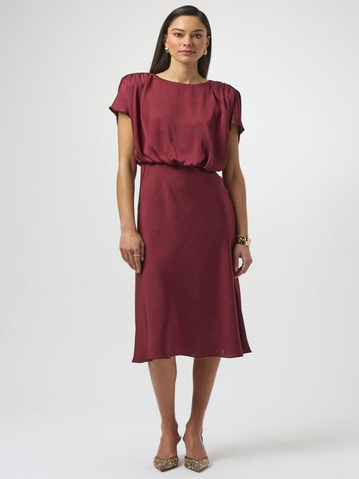 Woman wearing a burgundy dress on a white background