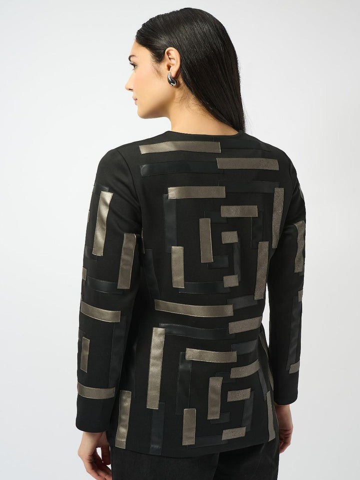 Woman wearing a black jacket with geometric patterns on a white background