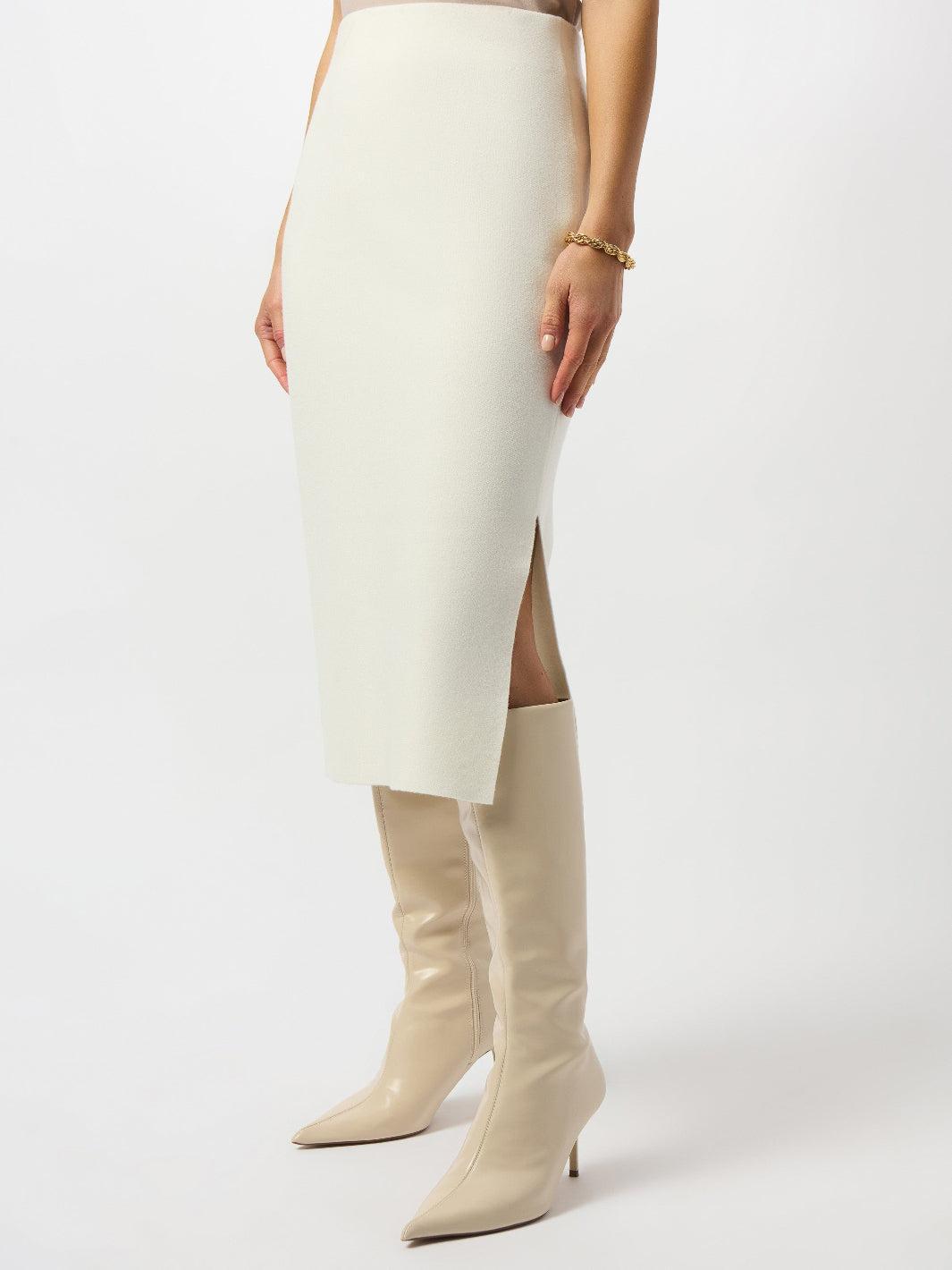 White pencil skirt with a high slit and matching knee-high boots on a white background