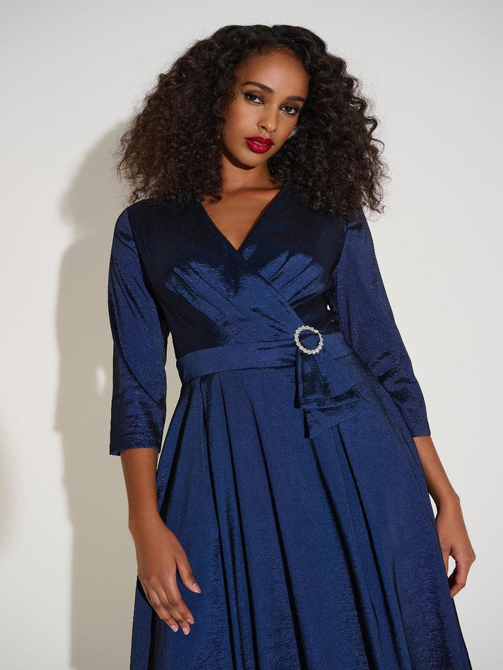 Woman wearing a blue dress with a belt against a white background