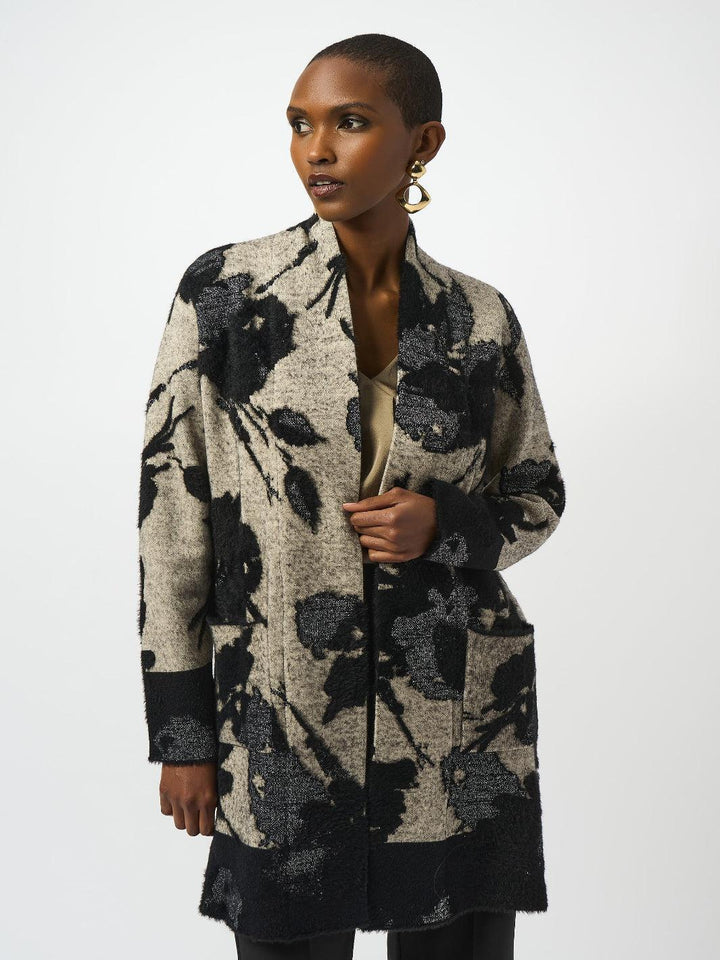 Woman wearing a long, patterned coat against a white background
