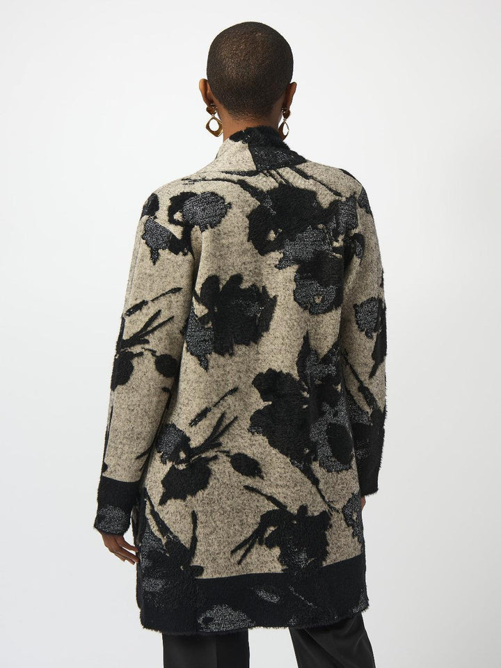 Person wearing a long floral-patterned coat on a white background