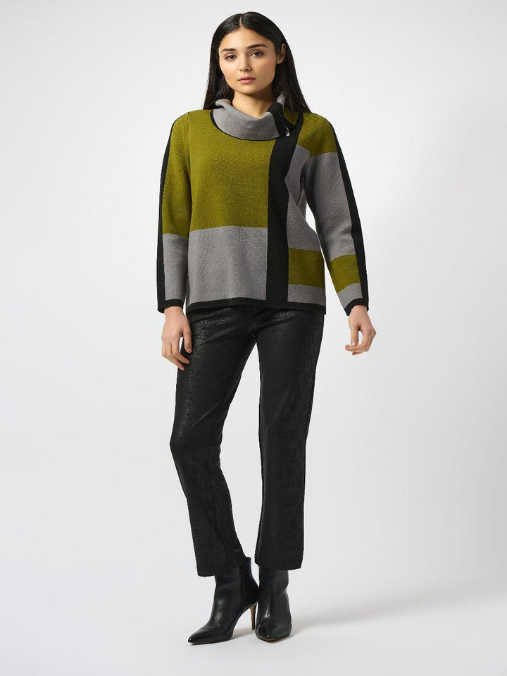 Woman wearing a color-blocked sweater and black pants on a white background