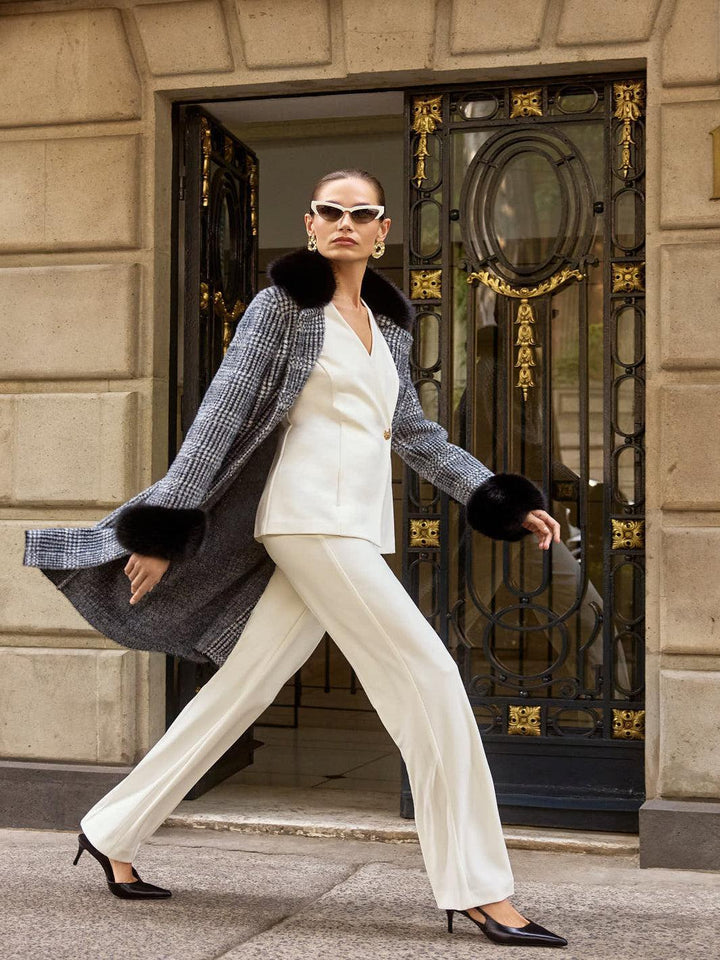 Woman in stylish outfit walking in front of a building entrance