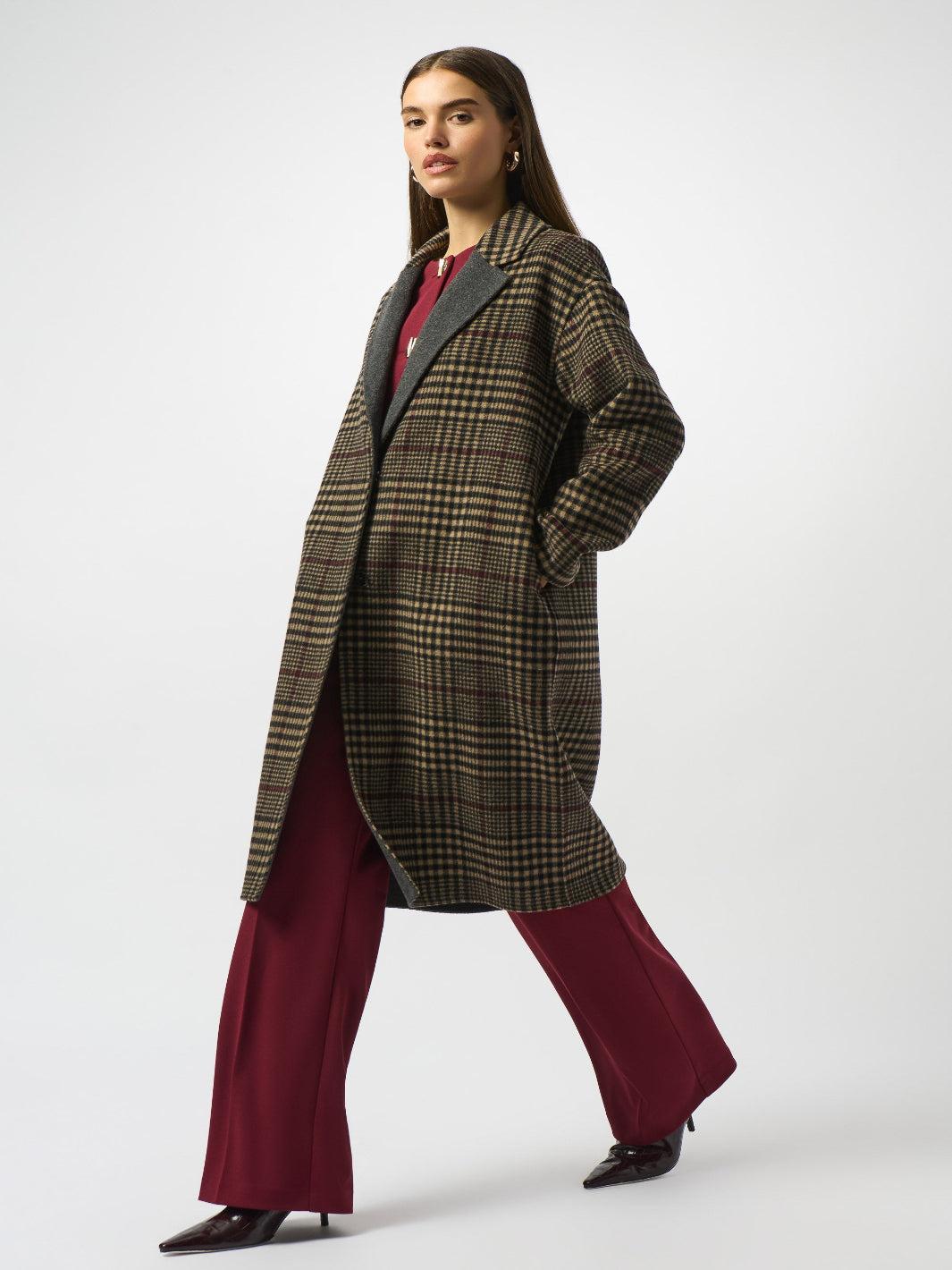 Woman wearing a plaid coat and burgundy pants on a white background