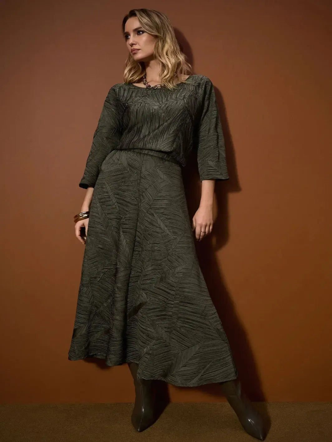 Woman wearing a green outfit against a brown background