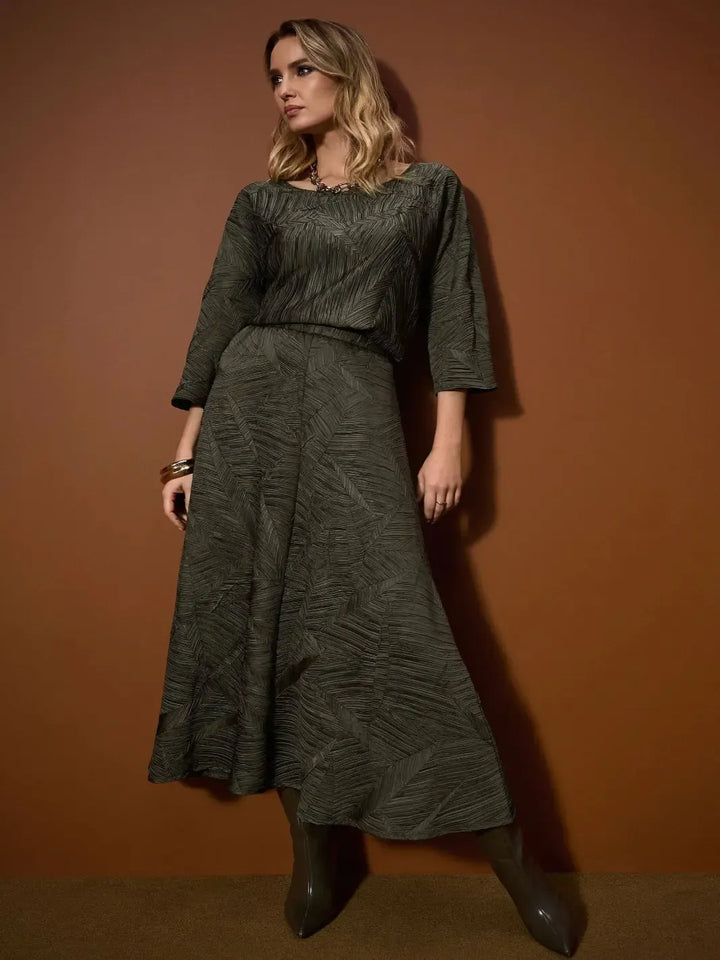 Woman wearing a green outfit against a brown background