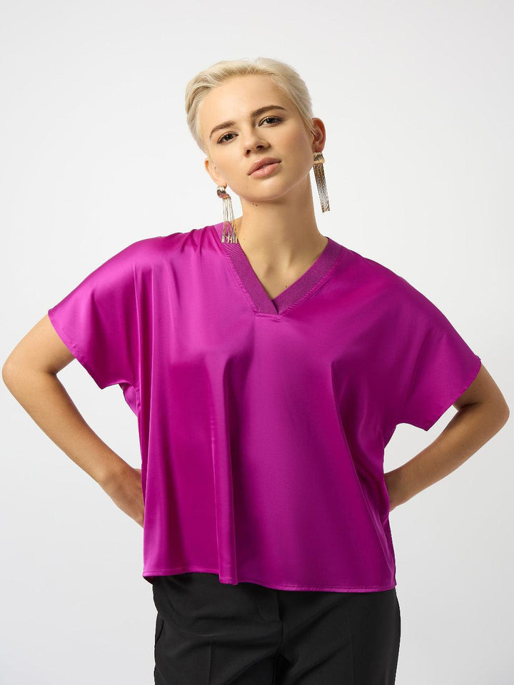Woman wearing a bright pink blouse on a white background