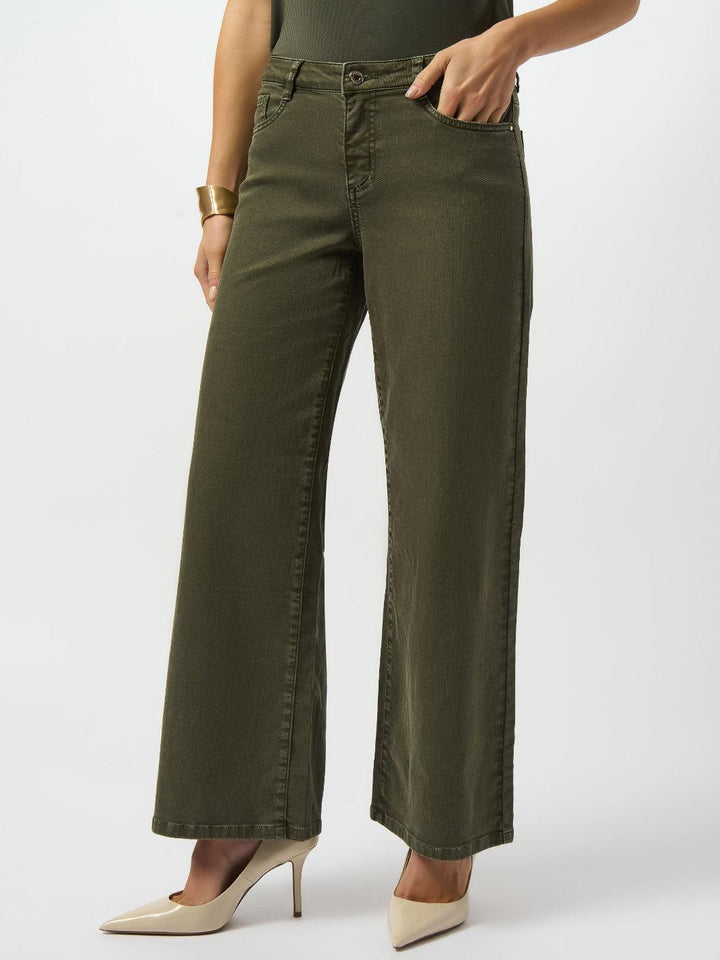 Person wearing olive green wide-leg jeans on a white background