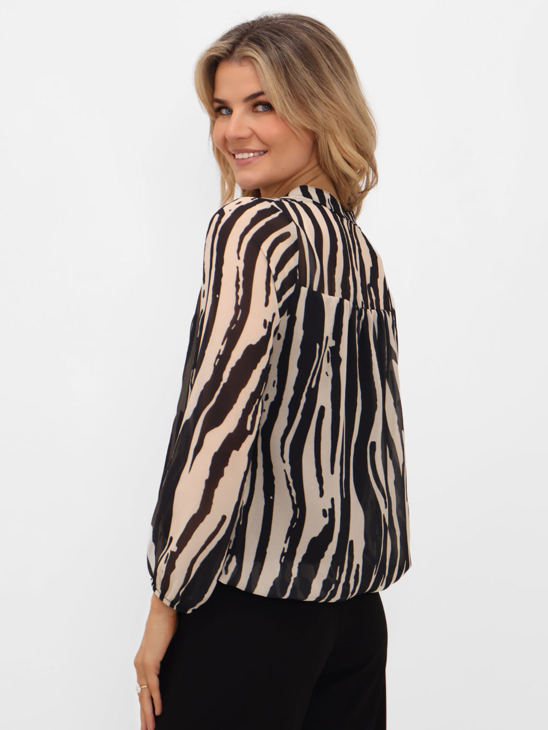 Woman wearing a zebra print blouse on a white background