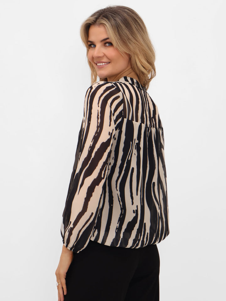 Woman wearing a zebra print blouse on a white background