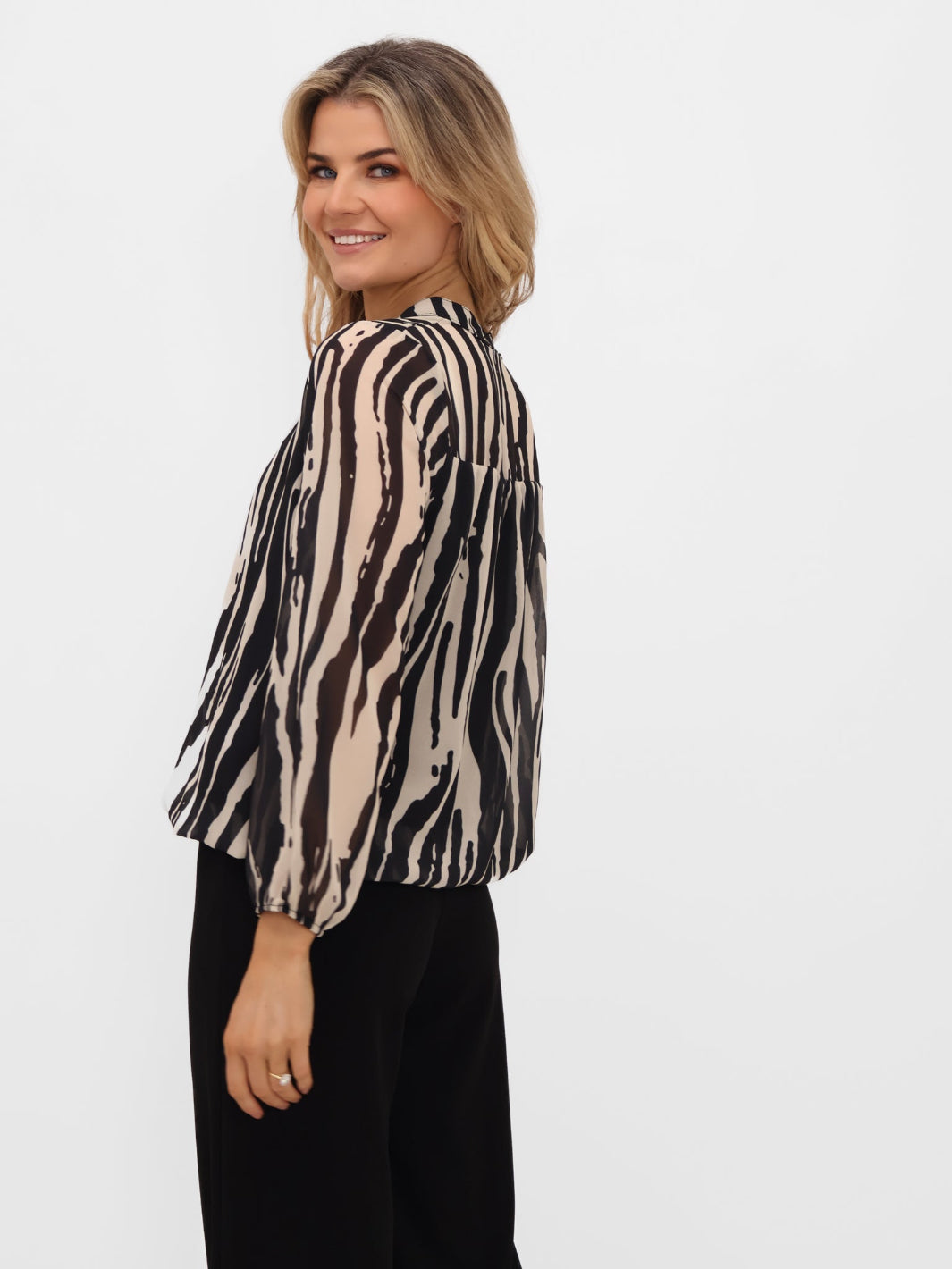 Woman wearing a zebra print blouse on a white background