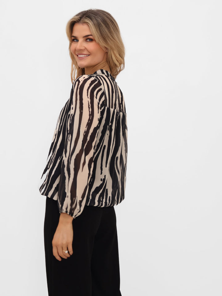 Woman wearing a zebra print blouse on a white background