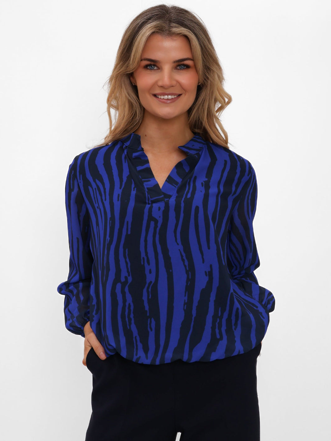 Woman wearing a blue and black patterned blouse on a white background