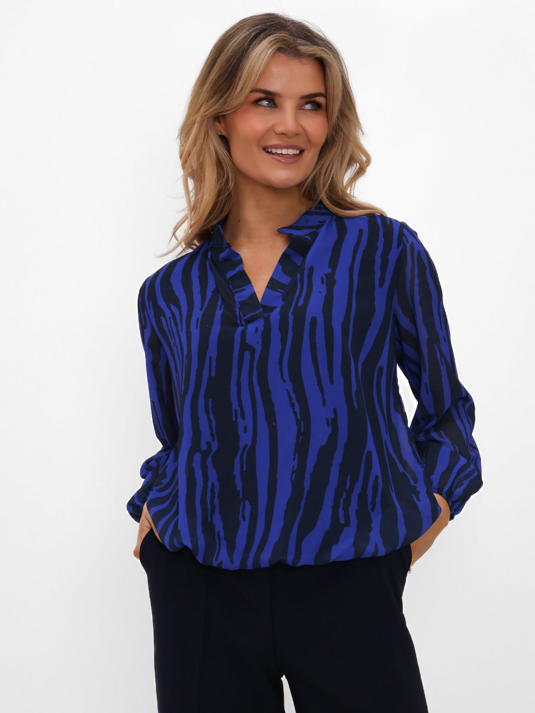 Woman wearing a blue zebra print blouse against a white background