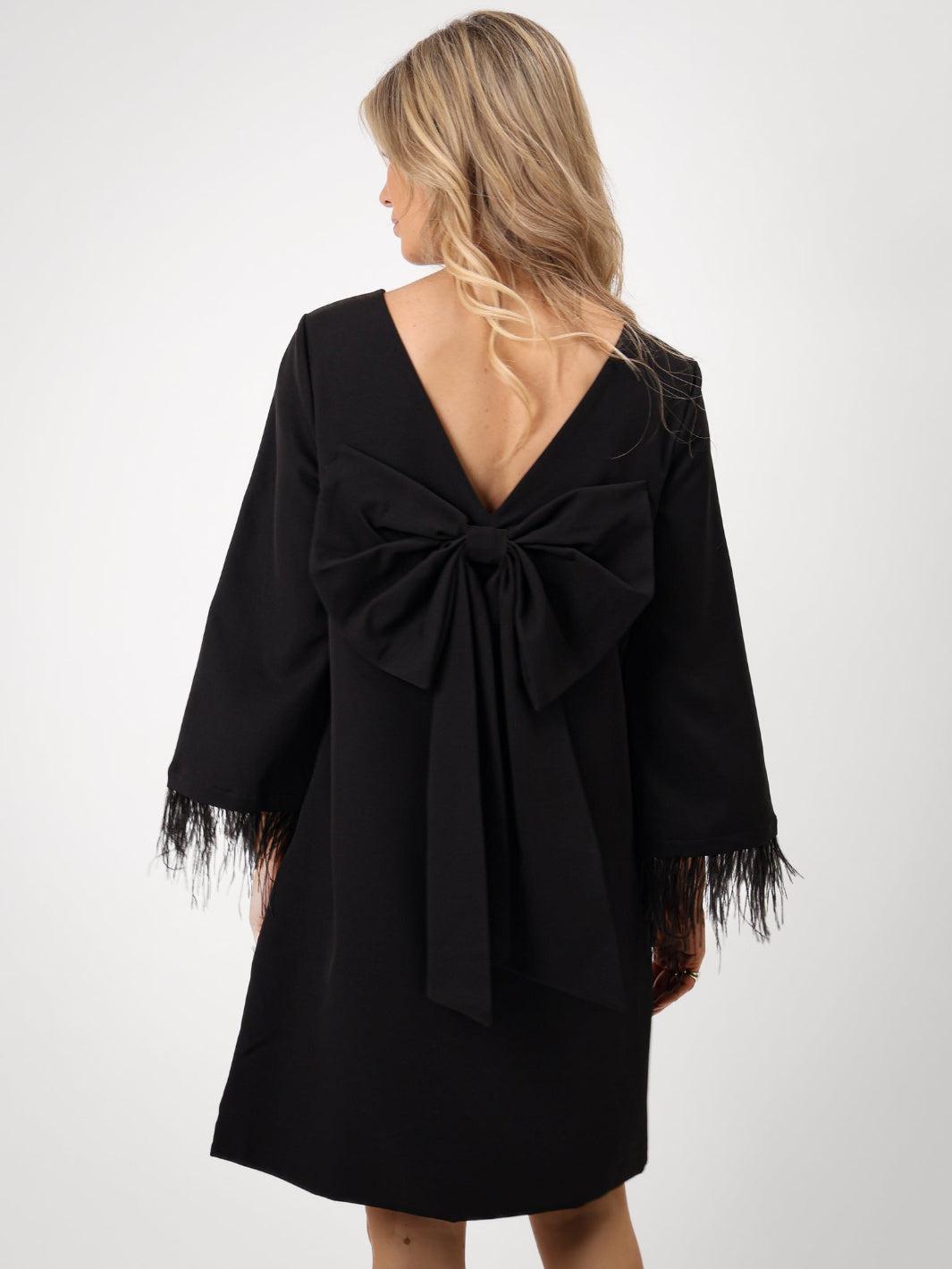 Black dress with a large bow detail on a white background