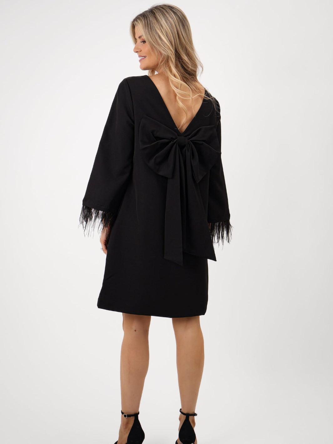 Black dress with a bow detail on a white background