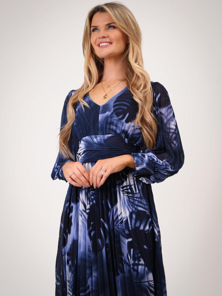 Woman wearing a blue patterned dress against a white background