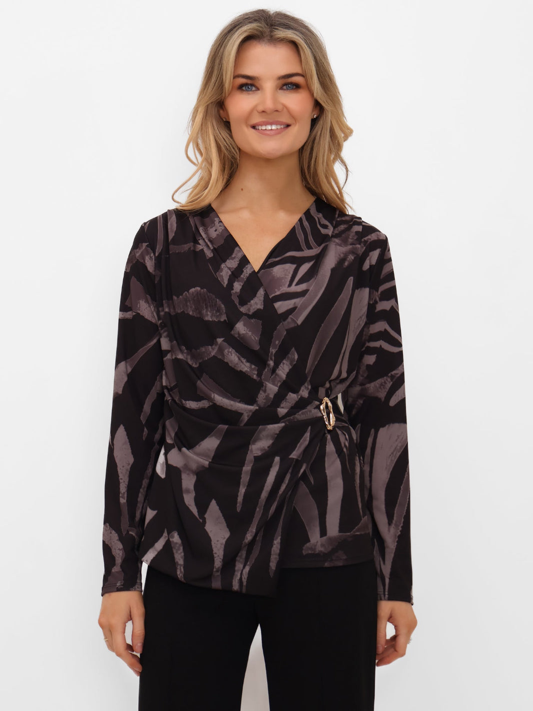 Woman wearing a patterned top with a belt on a white background