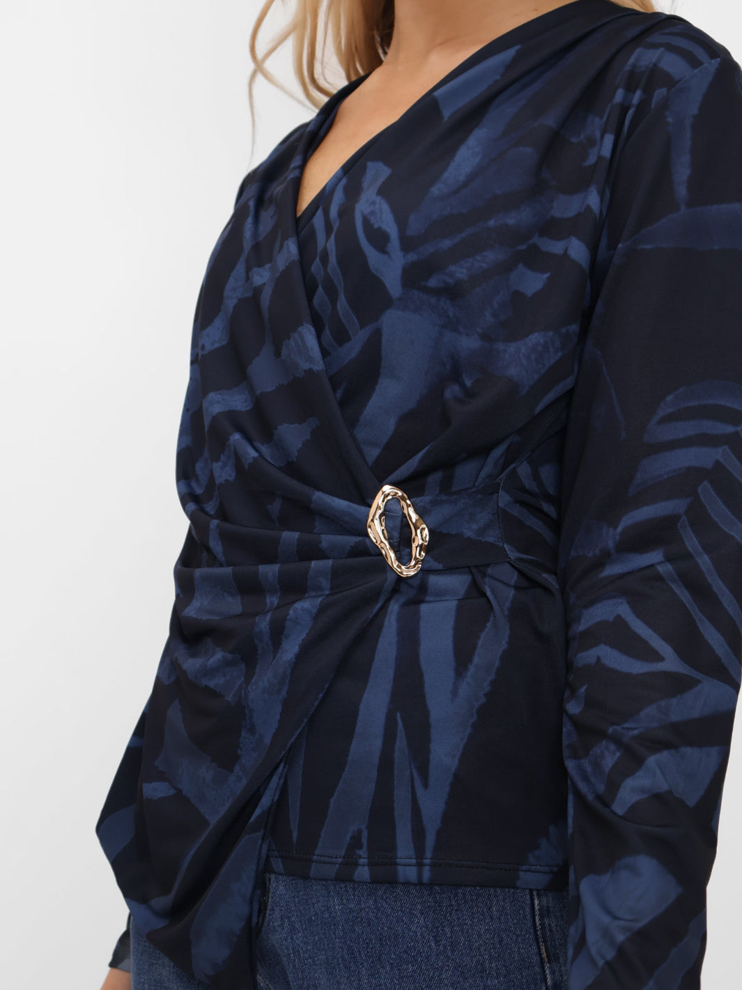 Navy patterned top with a gold belt on a white background