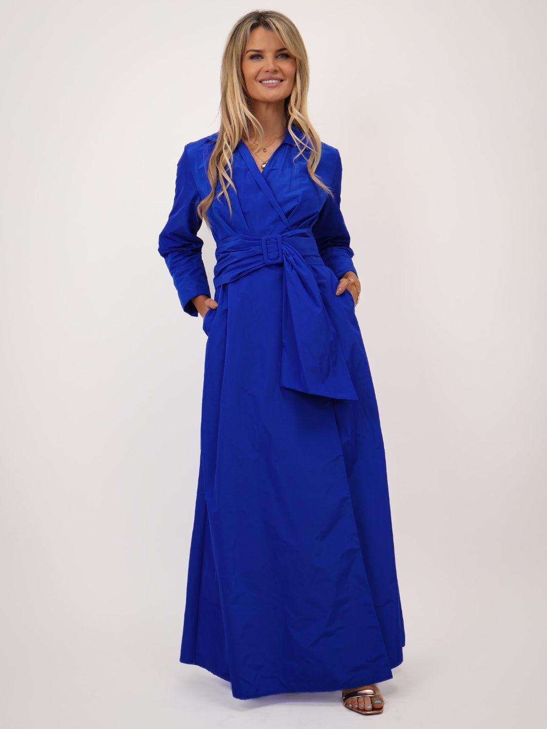 Woman wearing a blue dress with a belt on a white background