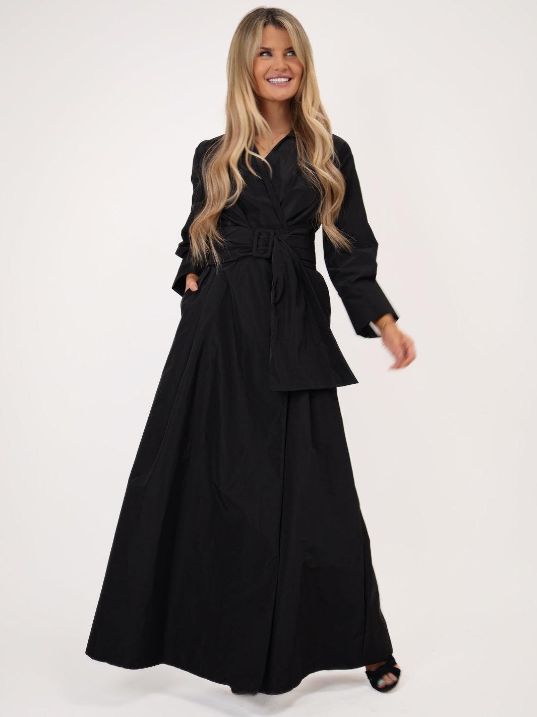 Woman wearing a black dress with a belt on a white background