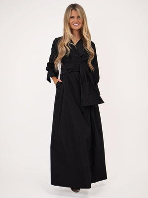 Woman wearing a black dress with a belt on a white background